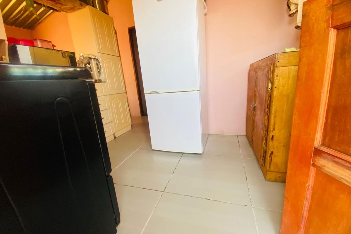 A functional kitchen area featuring tiled flooring and built-in cabinetry, offering a practical layout for daily food preparation and storage.