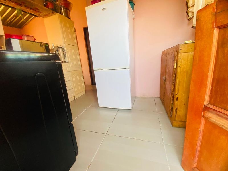 A functional kitchen area featuring tiled flooring and built-in cabinetry, offering a practical layout for daily food preparation and storage.