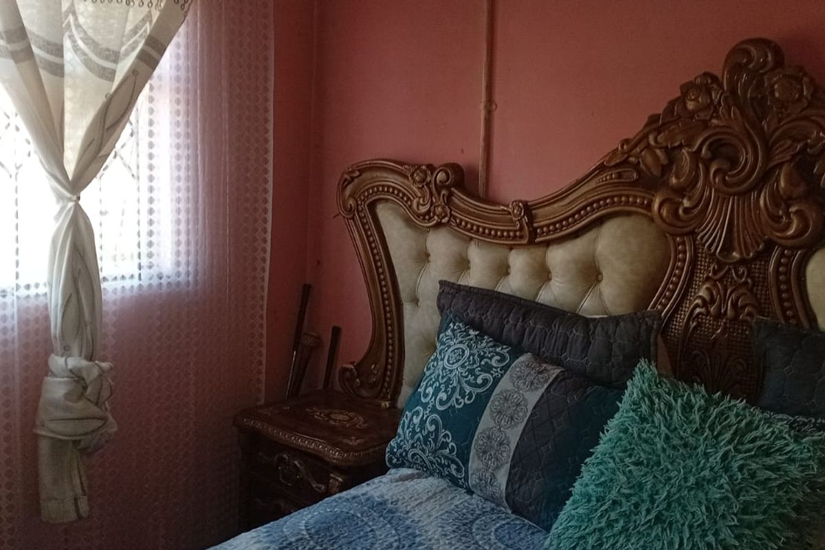 A bedroom featuring a window with an integrated security gate, providing natural light and essential security features.