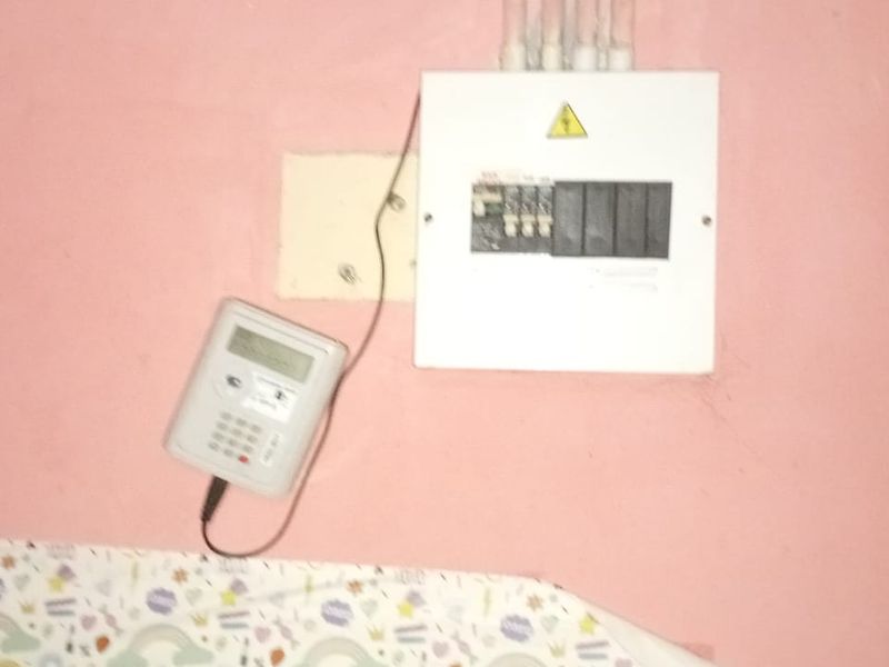 Utility area featuring a wall-mounted electrical distribution board and a prepaid electricity meter.
