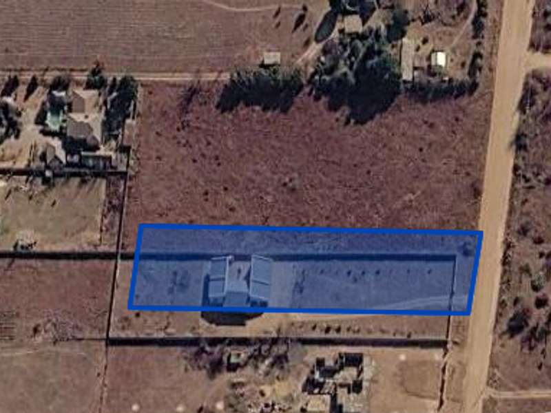Aerial view of the property plot showing the building footprint, boundary walls, and surrounding land access.