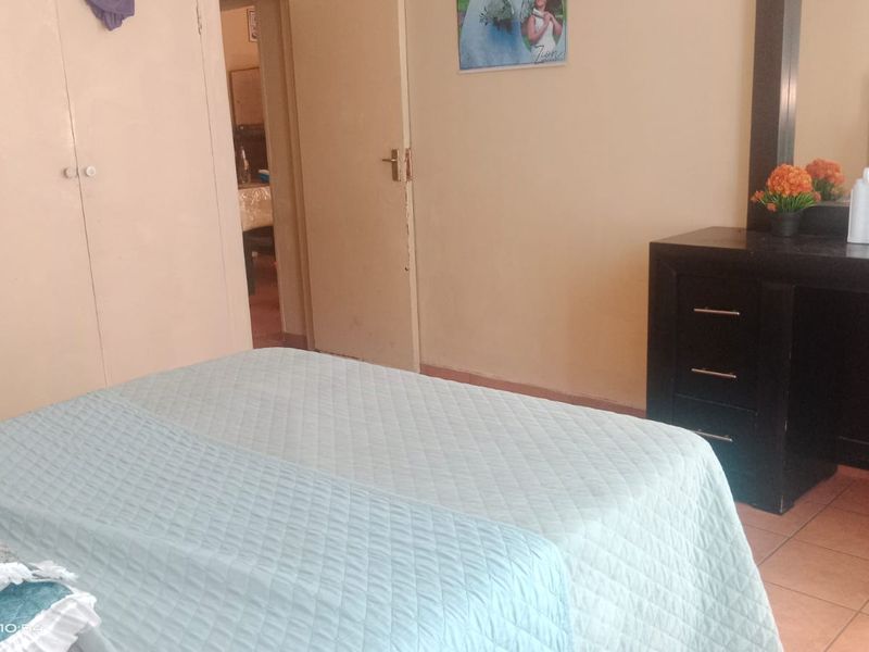 A bedroom featuring built-in wardrobes and tiled flooring, offering a functional space with standard finishes.