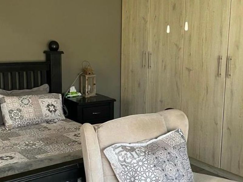 A bedroom featuring light wood-grain built-in cupboards providing ample storage space.