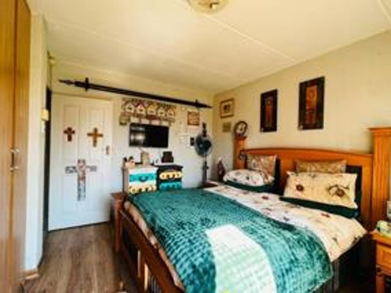 A functional bedroom featuring laminate flooring and a built-in wardrobe, offering a comfortable and practical living space.