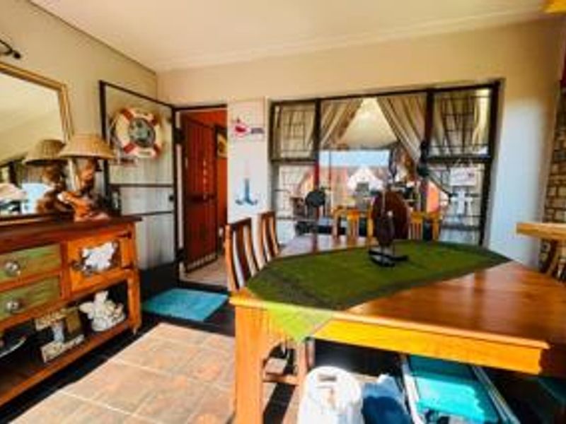 A dining area featuring tiled flooring and large windows, providing a bright and functional space for meals.