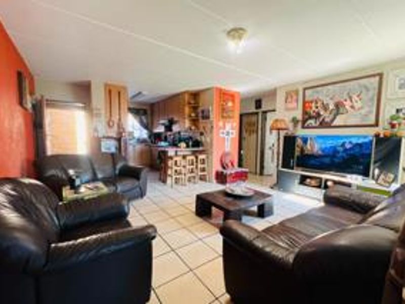 Open-plan living and kitchen area featuring ceramic tile flooring and a functional kitchen layout with a breakfast counter.
