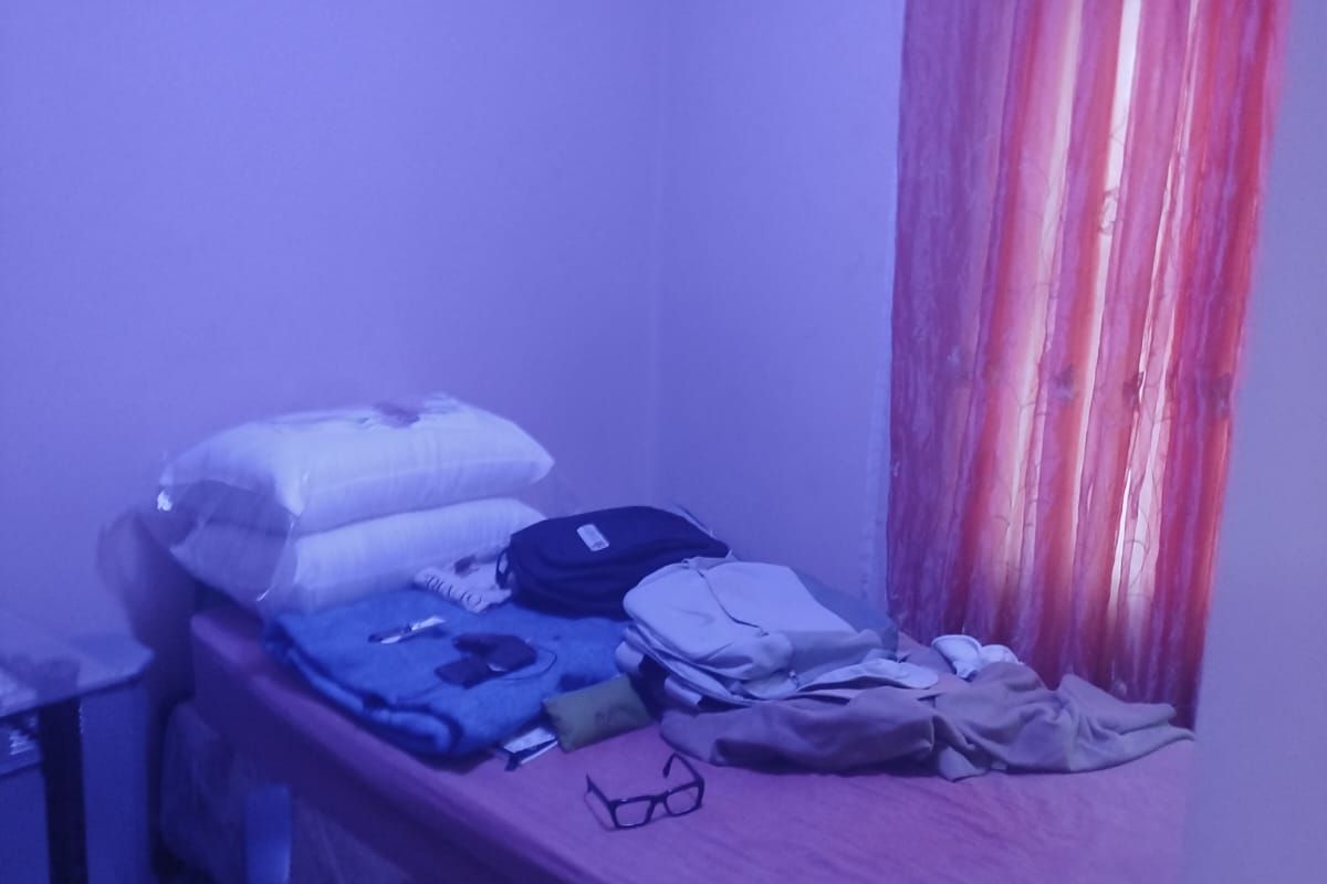 A standard bedroom featuring simple wall finishes and window treatments, suitable for a comfortable sleeping space.
