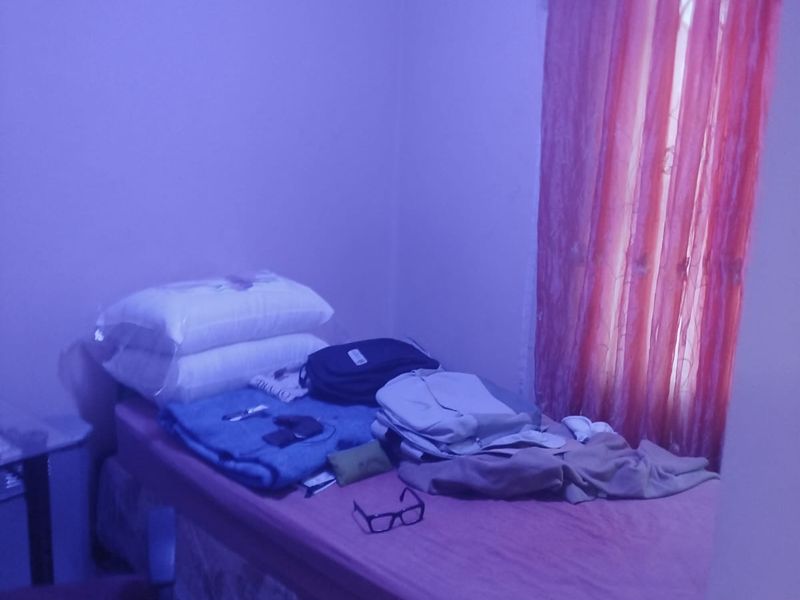 A standard bedroom featuring simple wall finishes and window treatments, suitable for a comfortable sleeping space.