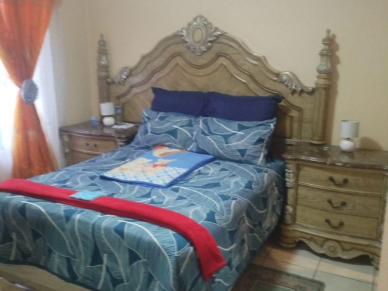 A standard bedroom featuring tiled flooring and decorative ceiling cornicing, providing a functional space for rest.