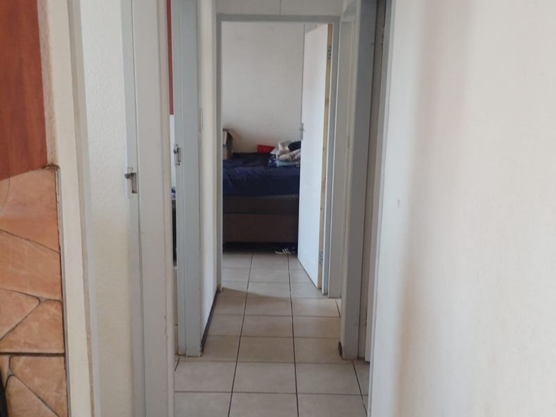 A functional hallway featuring tiled flooring and multiple doorways leading to adjacent rooms.