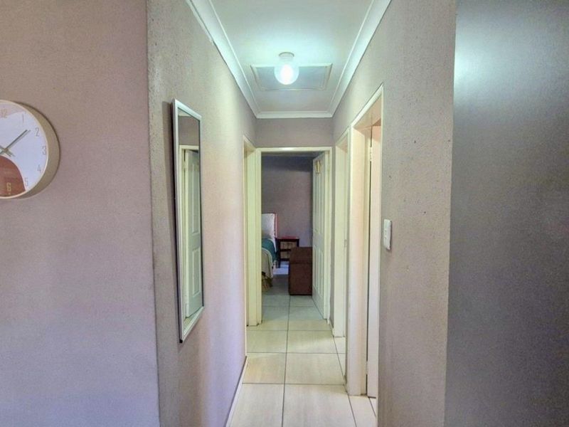 A functional interior hallway featuring tiled flooring and neutral wall finishes, providing access to adjacent rooms.