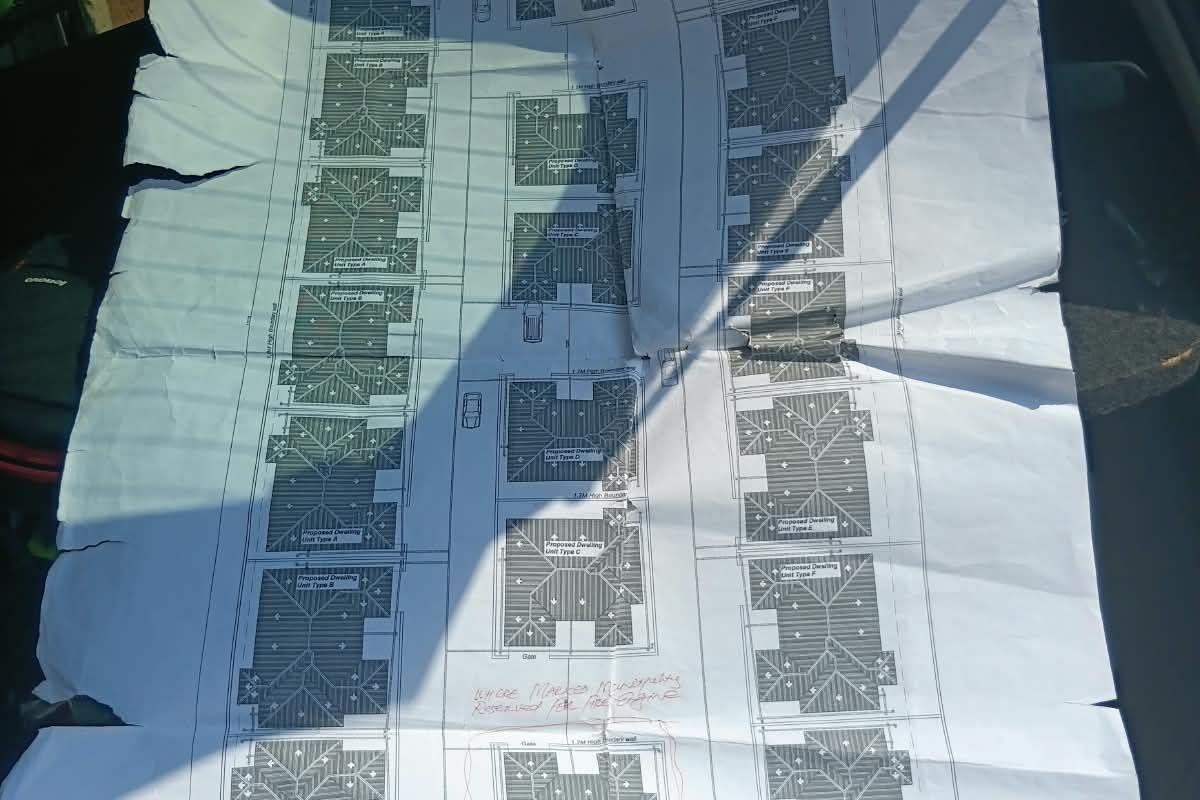 A printed site layout plan showing the proposed residential development and unit positioning on the land.
