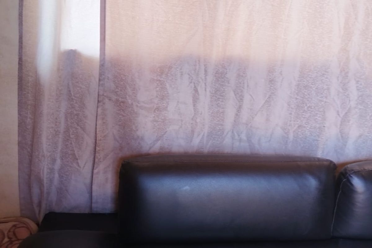 A close-up view of a living room wall showing visible staining and surface wear.