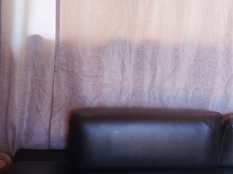 A close-up view of a living room wall showing visible staining and surface wear.