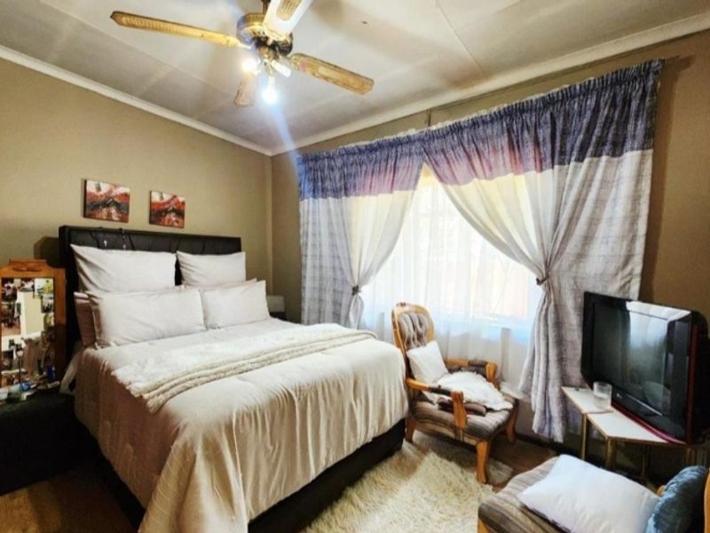 A bedroom featuring a ceiling fan and coved ceiling details, providing a functional space with standard finishes.