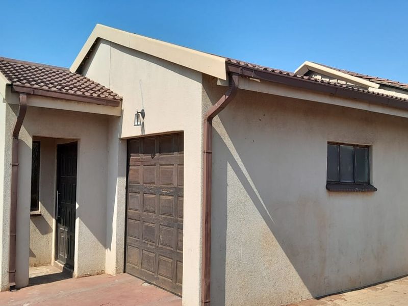Front exterior view of a single-story house featuring a tiled roof, integrated garage, and standard window and door fixtures.