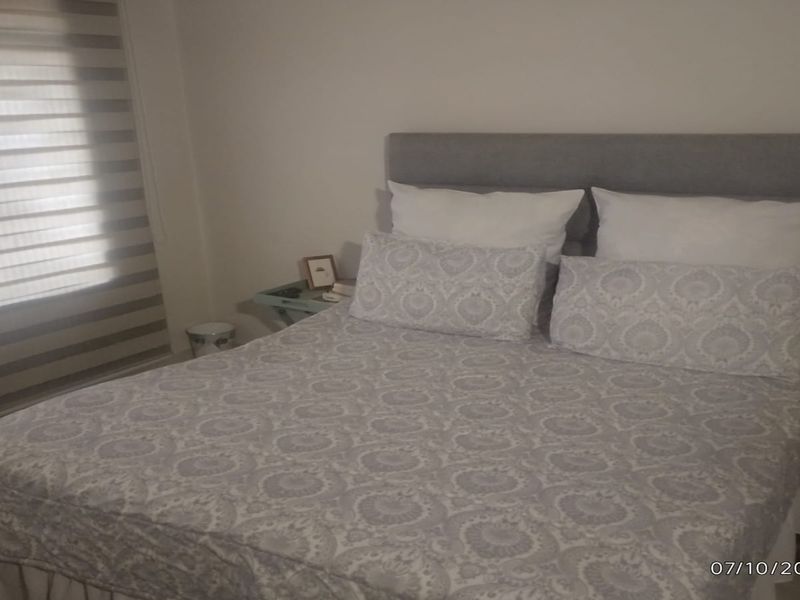 A bedroom featuring neutral walls and modern roller blinds, providing a clean and functional space.