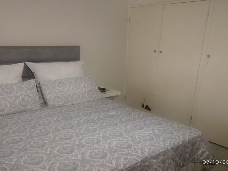 A bedroom featuring a built-in wardrobe with visible damage to the lower door panel.