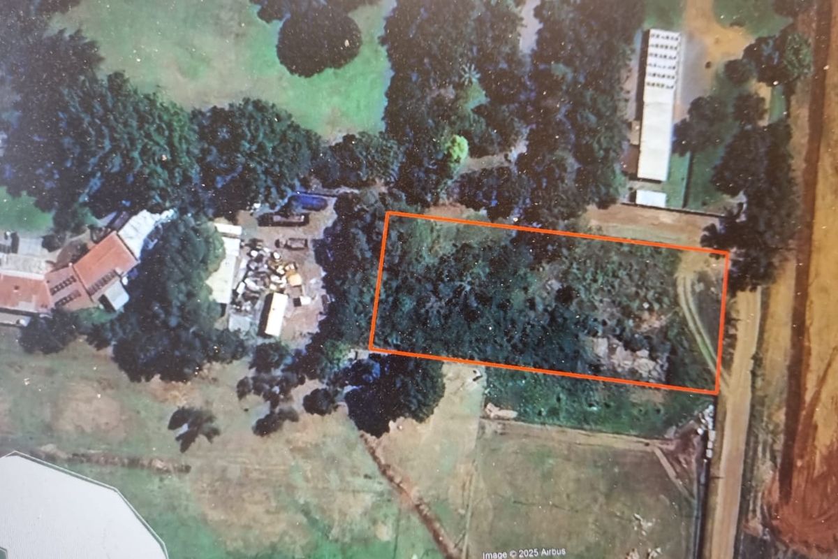 Aerial view of a vacant residential plot featuring dense vegetation and natural terrain.