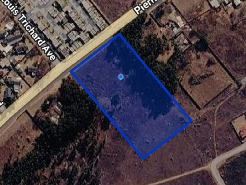 Aerial view of a vacant residential plot with street frontage, suitable for development.