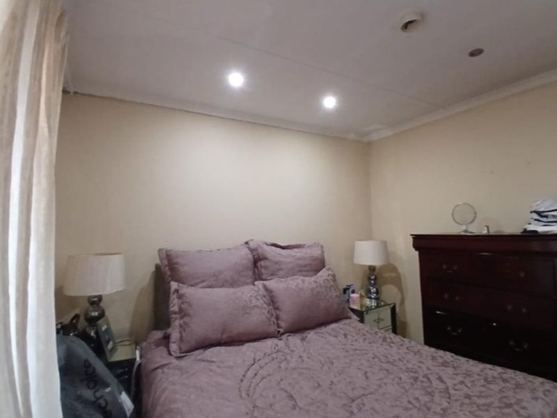 A standard bedroom featuring recessed downlighting and coved ceiling finishes.