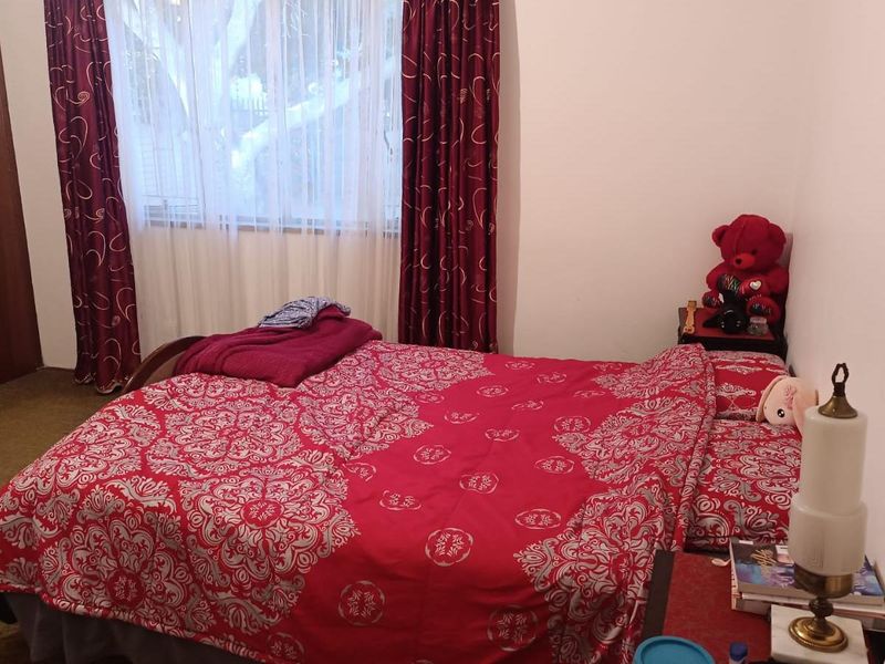 A functional bedroom featuring carpet flooring and a built-in wardrobe, offering a comfortable and practical living space.