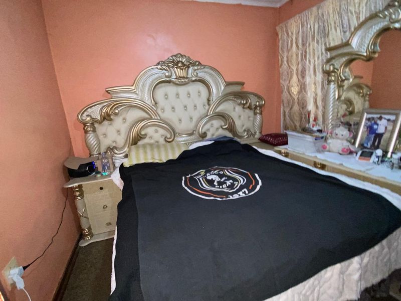 A bedroom featuring a classic layout with wall-mounted curtain rails and standard electrical outlets.