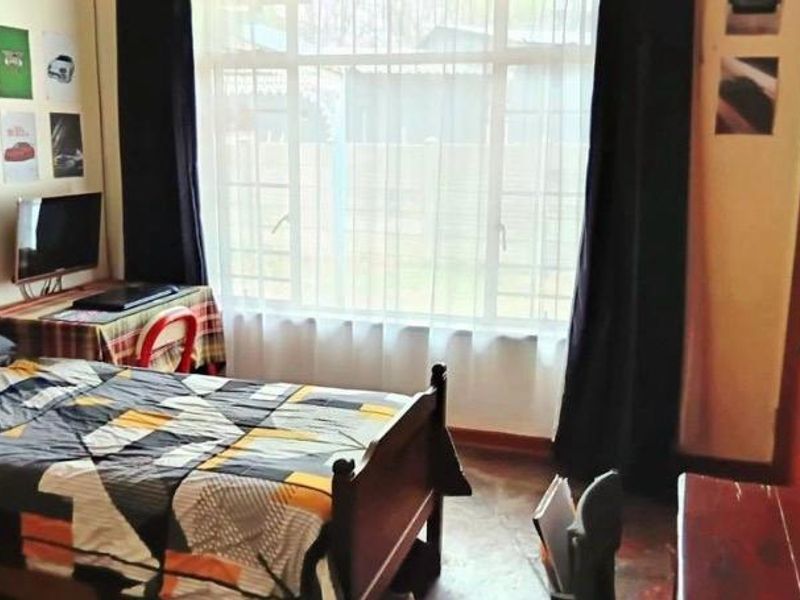 A bedroom featuring a large window that allows natural light, complemented by built-in storage space.