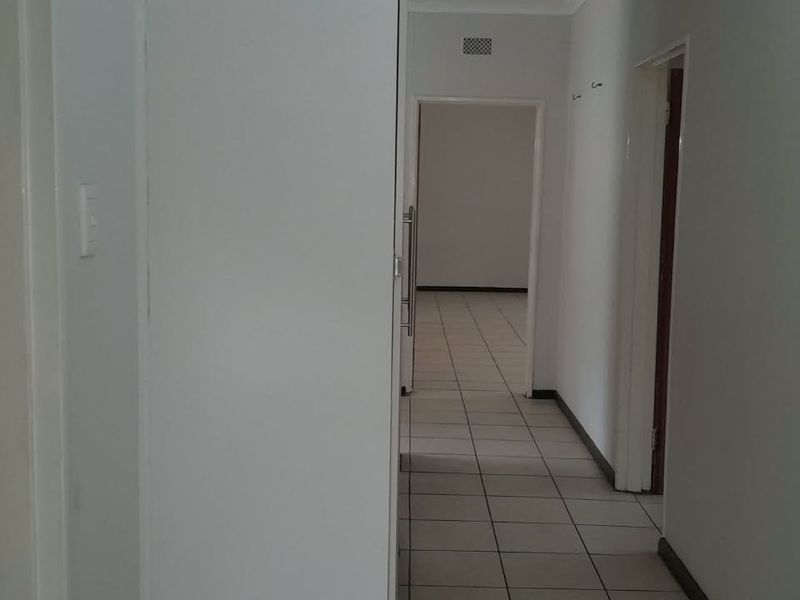 A functional hallway featuring tiled flooring and built-in storage, providing access to adjacent rooms within the home.