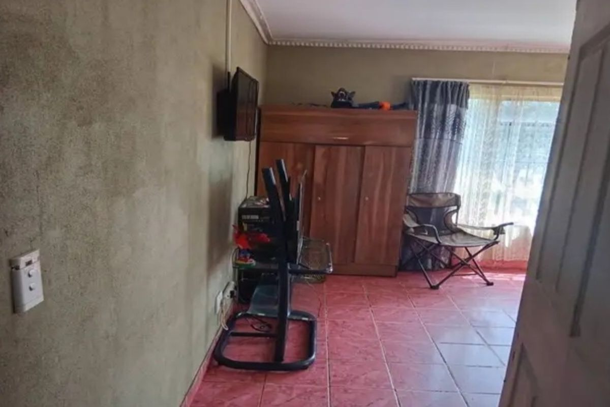 A living room area featuring tiled flooring and unfinished wall surfaces, providing a blank canvas for potential interior updates.