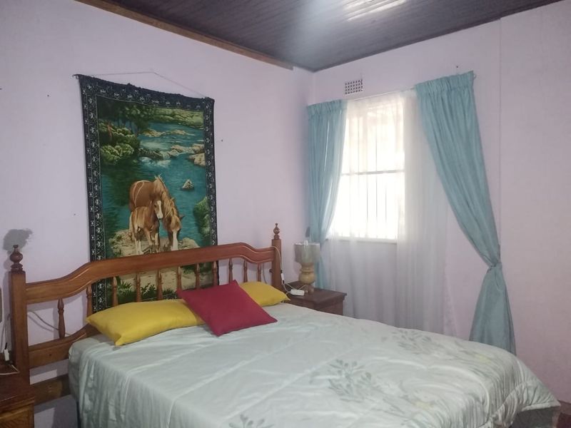 A bedroom featuring a timber ceiling and security bars on the window, requiring cosmetic updates to improve the overall aesthetic and condition.