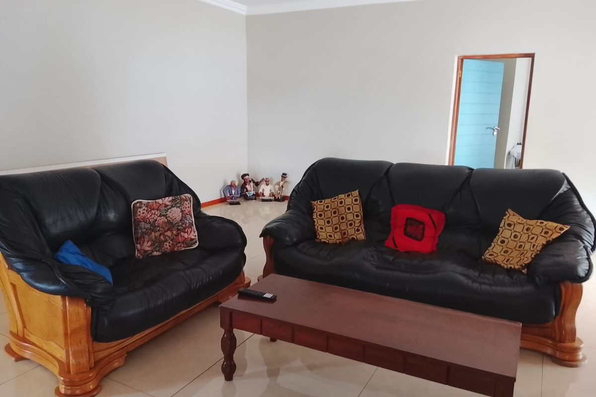 A spacious living room featuring neutral wall tones and tiled flooring, providing a versatile area for relaxation and family gatherings.