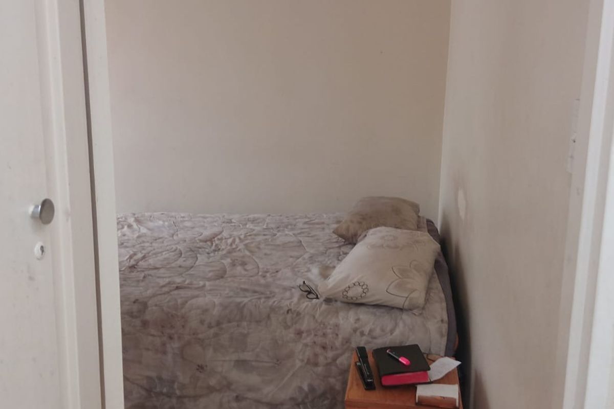 A compact bedroom featuring plain walls and standard door access, requiring minor cosmetic updates to refresh the space.