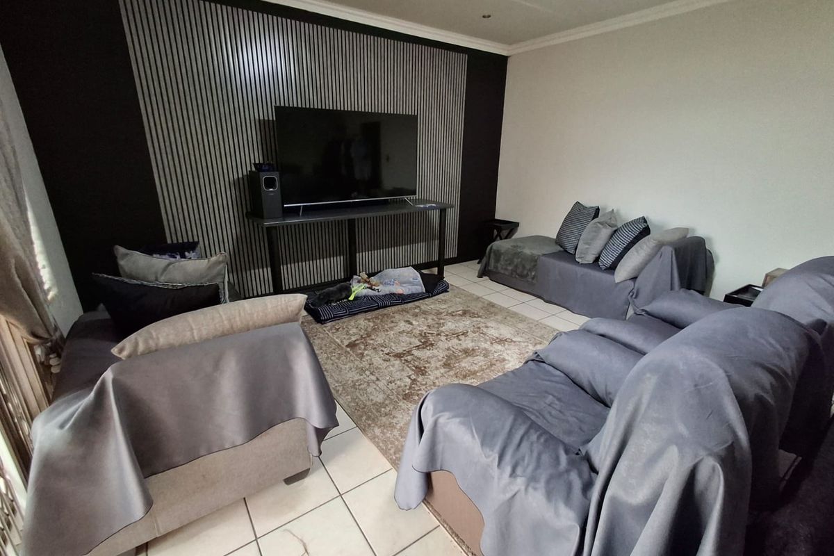 A living room featuring a decorative slatted feature wall and tiled flooring.