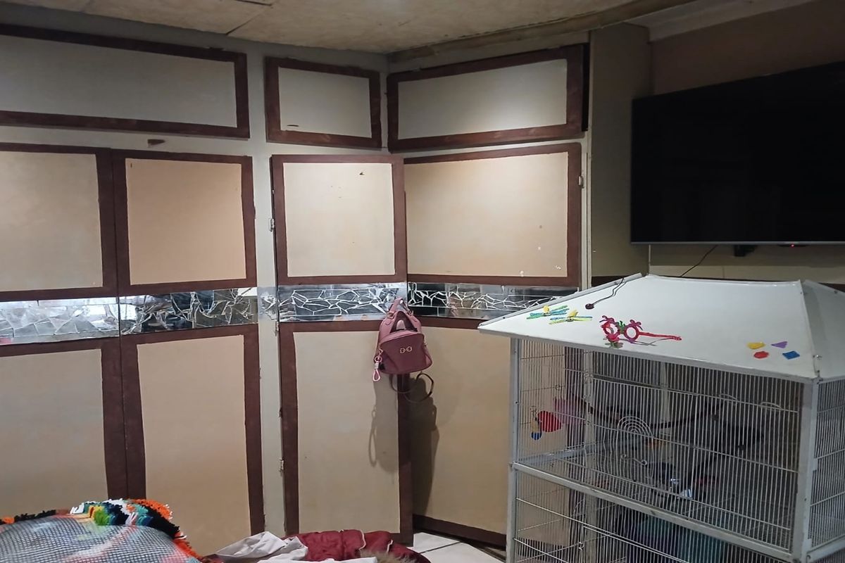 A bedroom featuring extensive built-in cabinetry with integrated mirror detailing and a wall-mounted television.