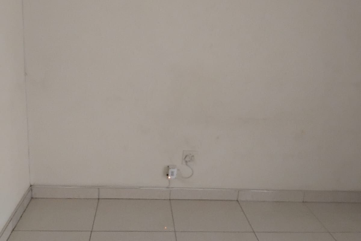 An empty bedroom featuring neutral tiled flooring and plain walls, providing a blank canvas for personalization.