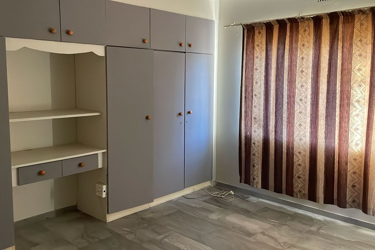 A bedroom featuring extensive built-in cabinetry with an integrated desk area, providing ample storage and workspace.