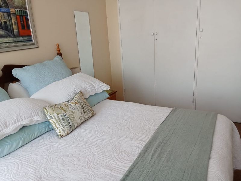 A bedroom featuring built-in cupboards with white doors, providing functional storage space within the room.