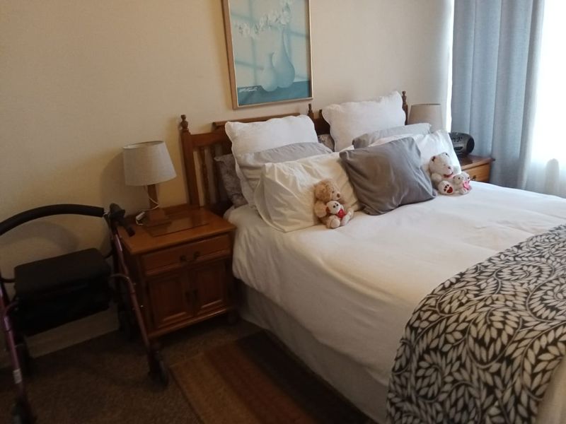 A standard bedroom featuring neutral wall finishes and carpeted flooring, providing a comfortable and functional living space.