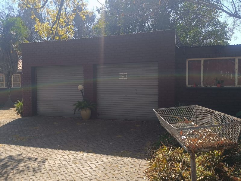 Exterior view of a double garage featuring brick construction and roller doors, situated on a paved driveway.