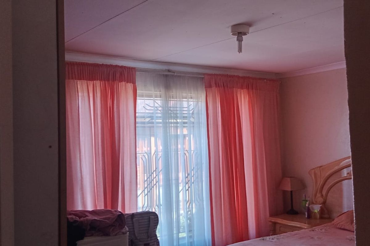 A bedroom featuring a window with security gate and standard ceiling finishes.