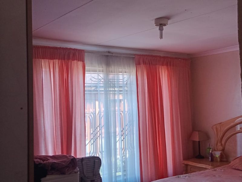 A bedroom featuring a window with security gate and standard ceiling finishes.
