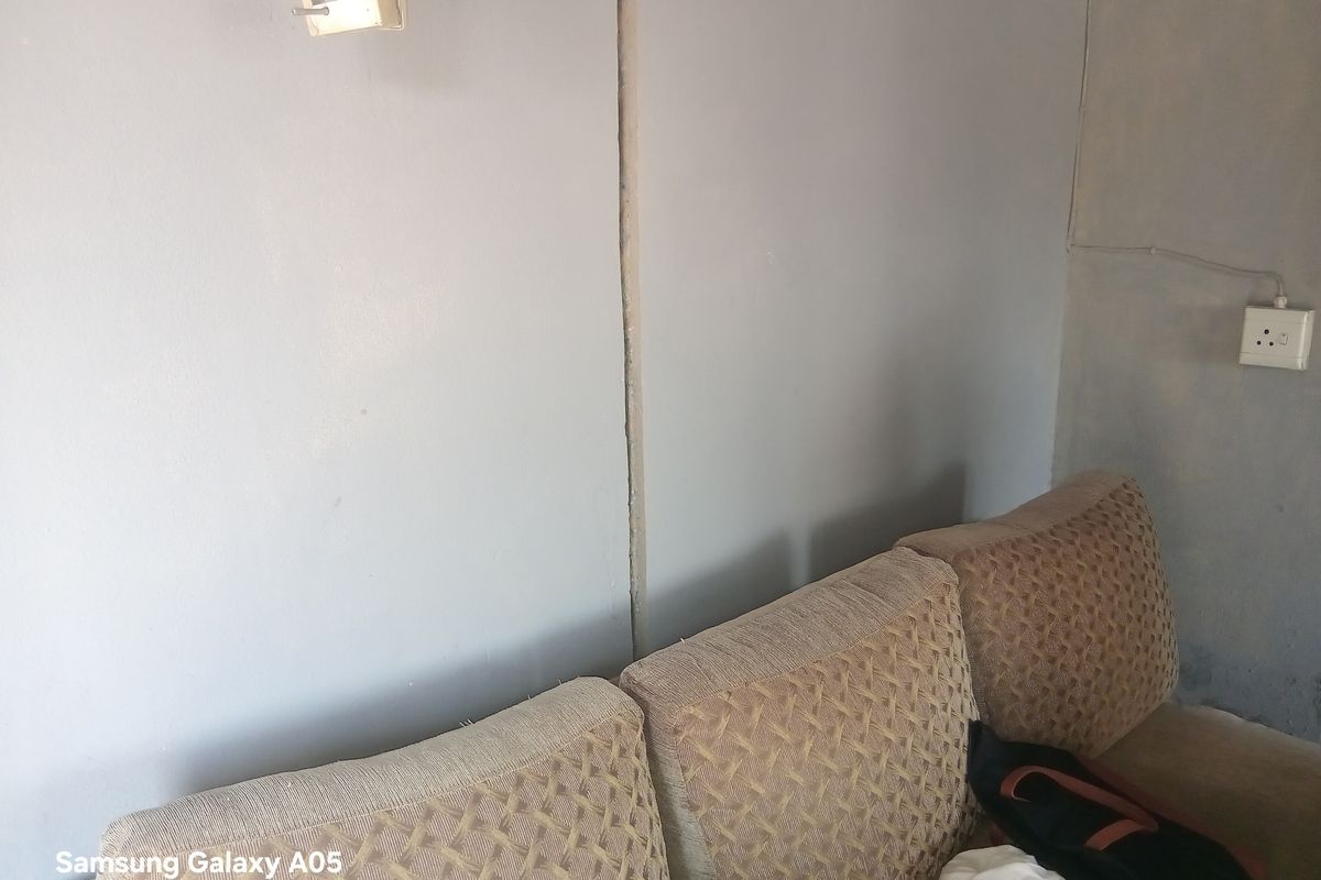 A close-up view of a living room wall showing visible joint lines and electrical fixtures.