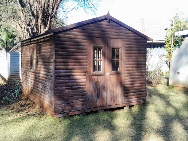 A detached timber utility shed or storage structure located in the rear garden area.