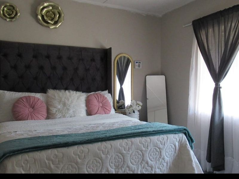 A bedroom featuring neutral wall tones and a window with installed curtain rods.
