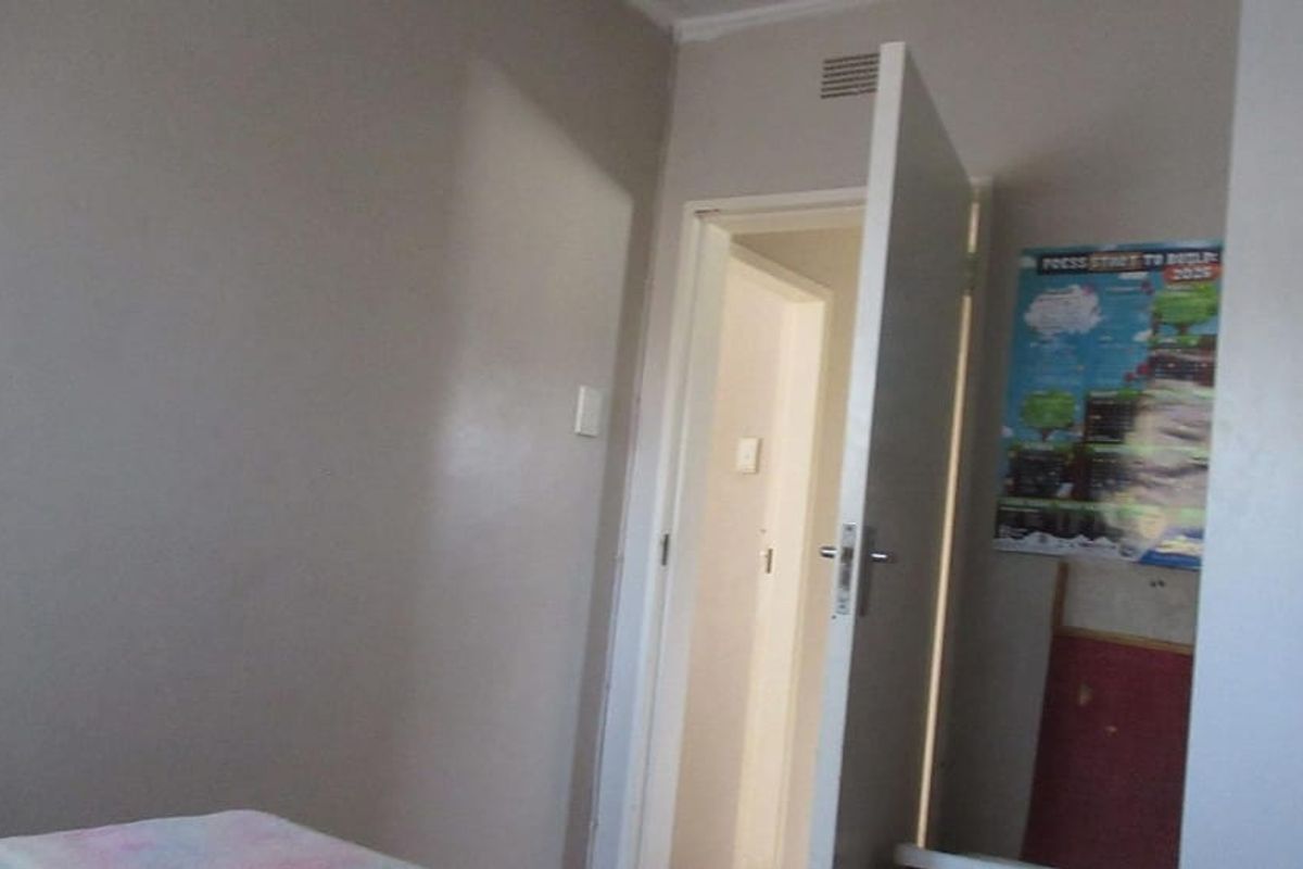 A simple bedroom interior featuring a standard internal door and ventilation grille, presenting a blank canvas for potential renovation or restyling.