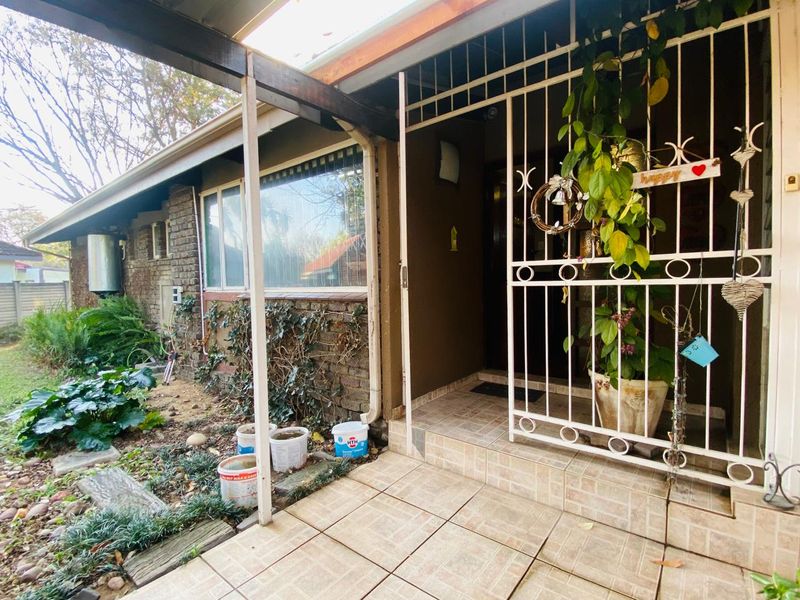 Covered entrance area featuring tiled flooring, a security gate, and direct access to the home's front facade.