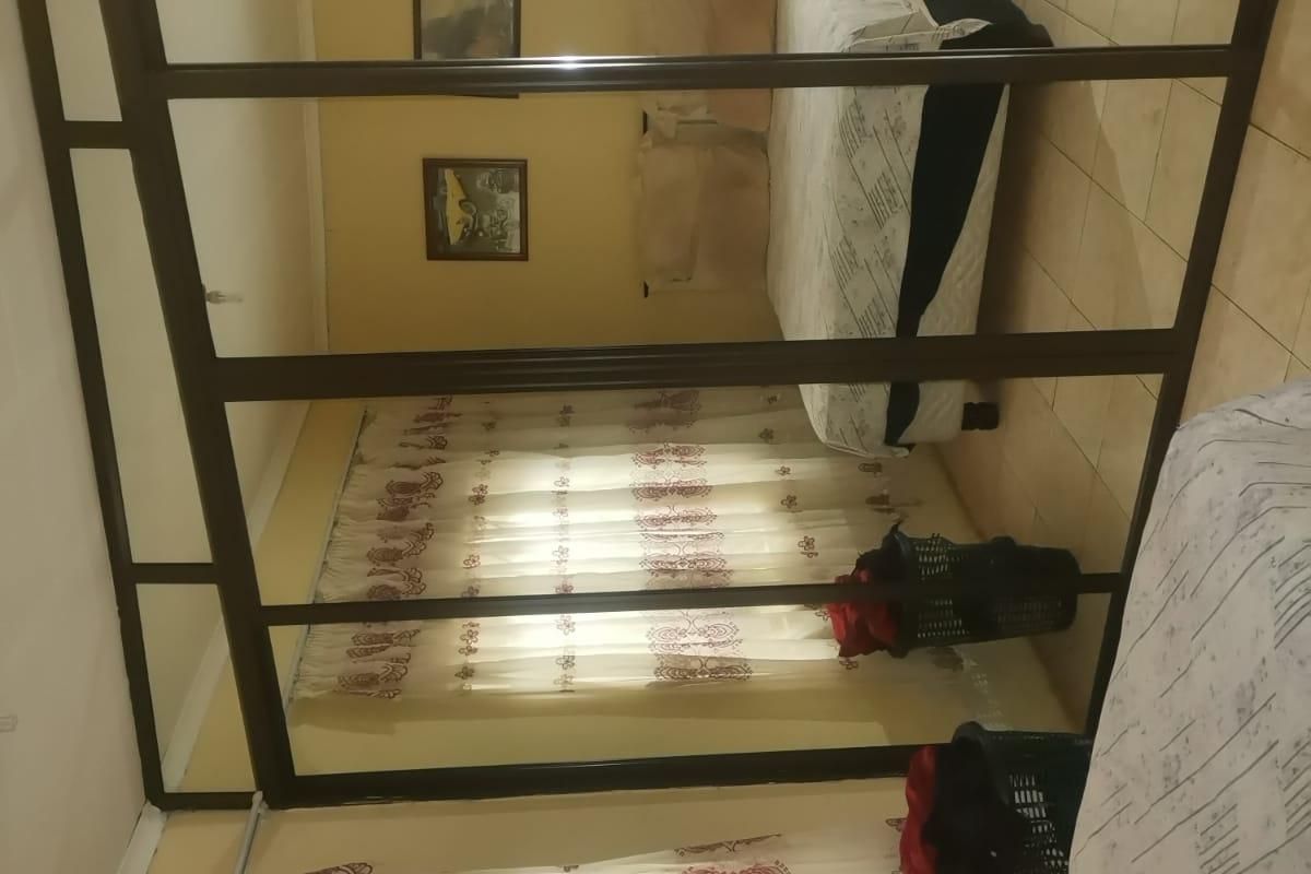 A bedroom featuring tiled flooring and a large built-in wardrobe with sliding mirror doors.