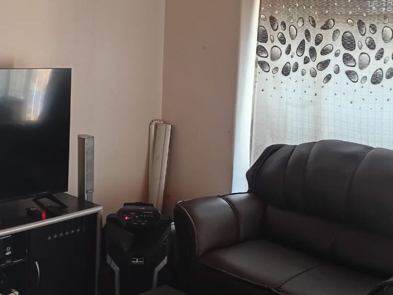 A living room area featuring a window with curtains, providing a functional space for relaxation.