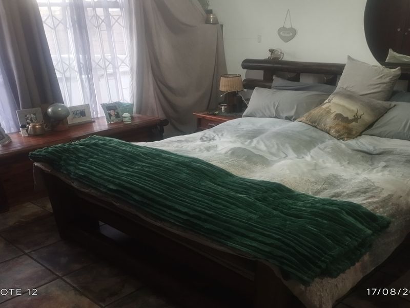 A bedroom featuring tiled flooring and a security gate on the window, providing a functional space with basic finishes.